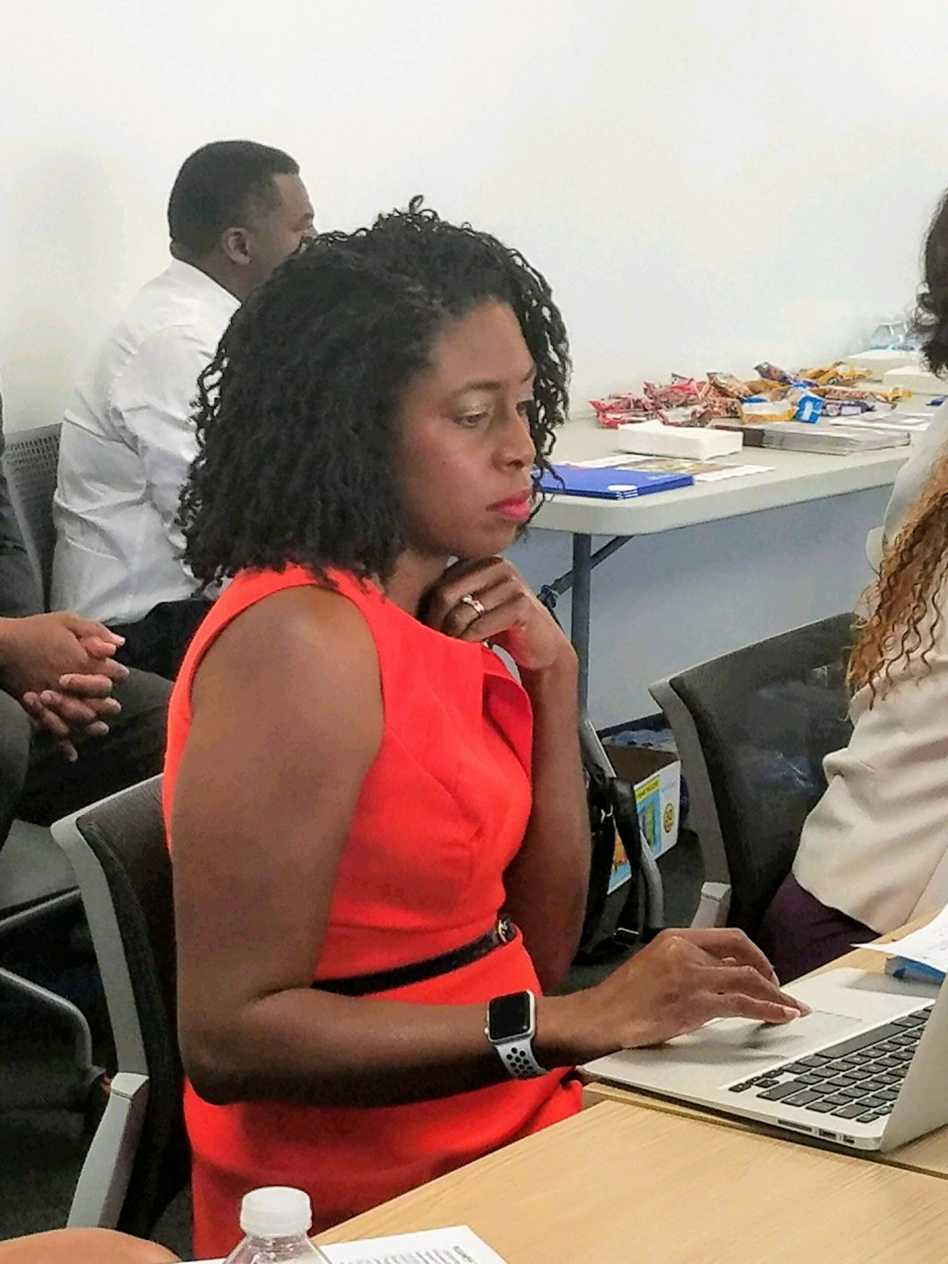 Woman in red dress working on laptop.